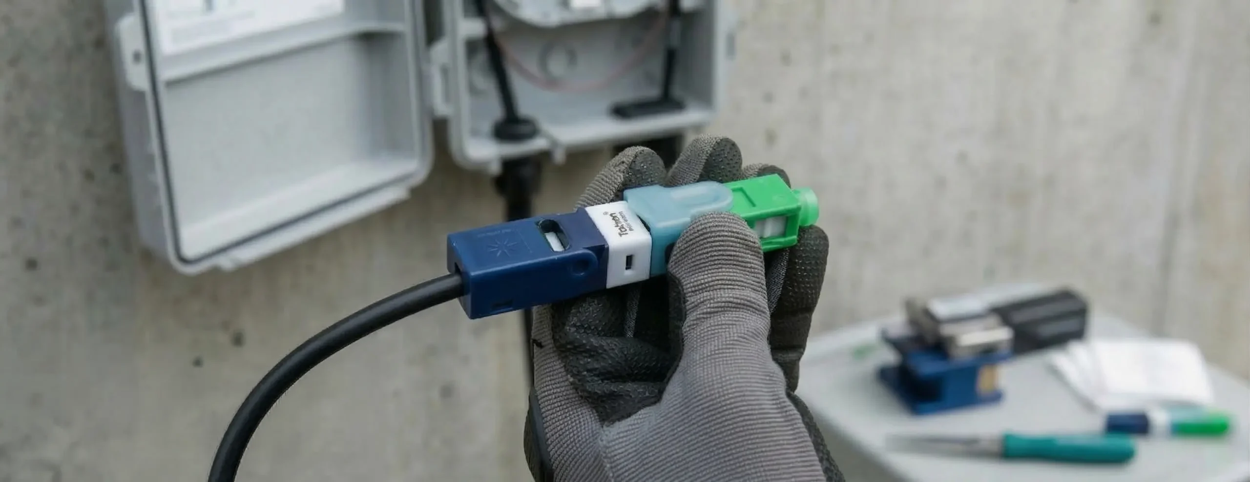 Pessoa segurando cabo drop com conector Taihan